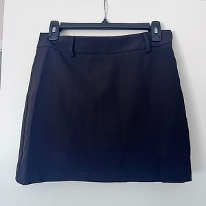 Commense mini black skirt with small slit on the left leg.